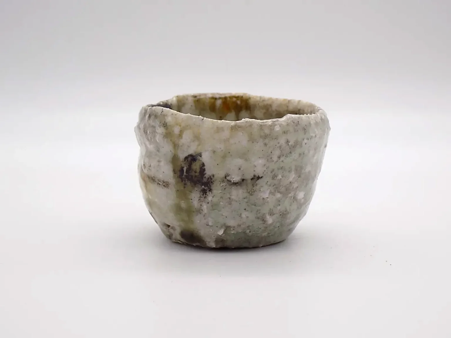 Hand-thrown sake cup with ash glaze, side view by Timi Lantos Ceramics