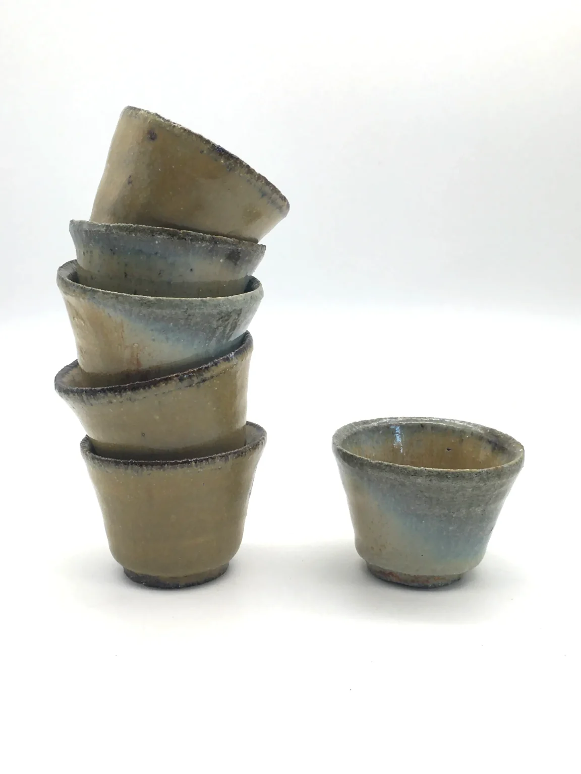 Stacked wood-fired anagama ochoko cups in brown tones, side view by Timi Lantos Ceramics