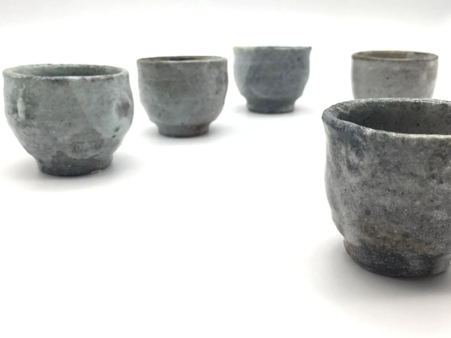 Five anagama firecolor reduction ochoko cups, side view by Timi Lantos Ceramics