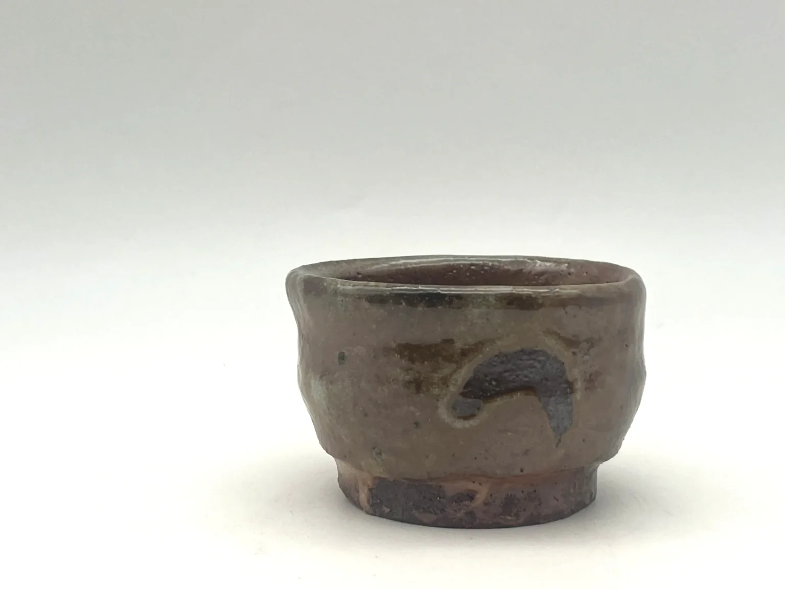 Wood-fired sake cup with earth mark impressions by Timi Lantos Ceramics
