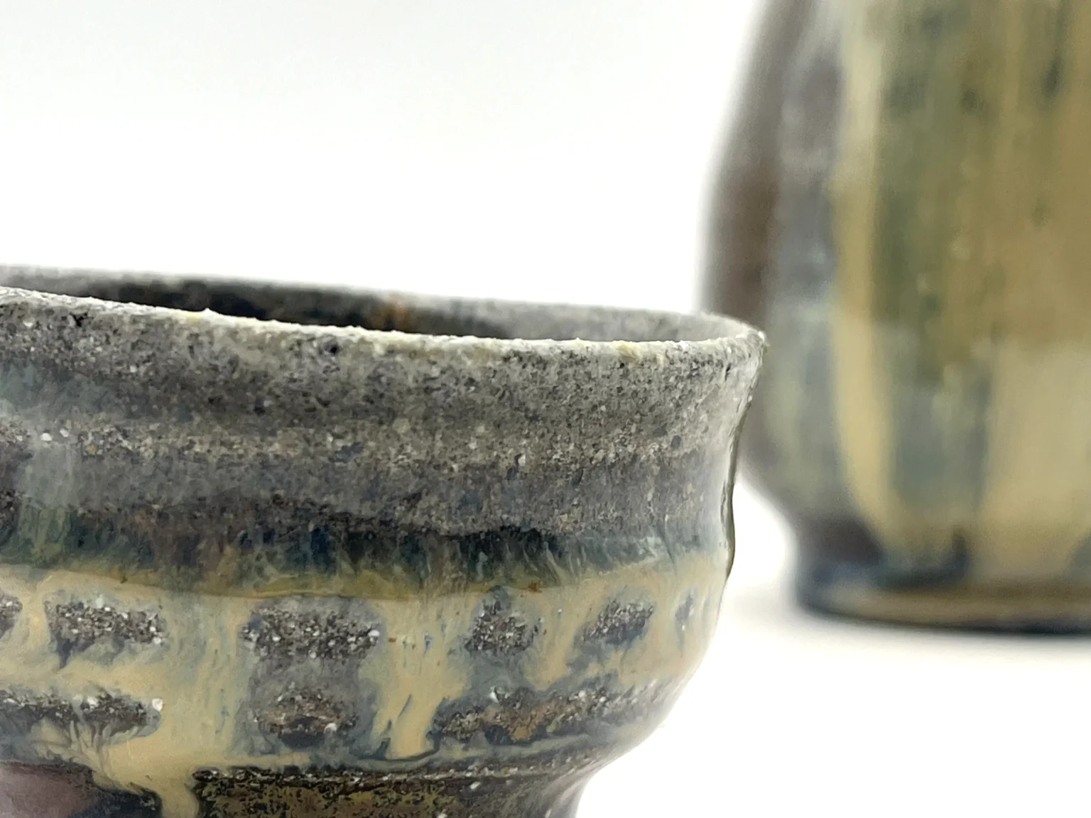 Close-up of a Tokkuri sake bottle and cup with beige ash glaze by Timi Lantos Ceramics