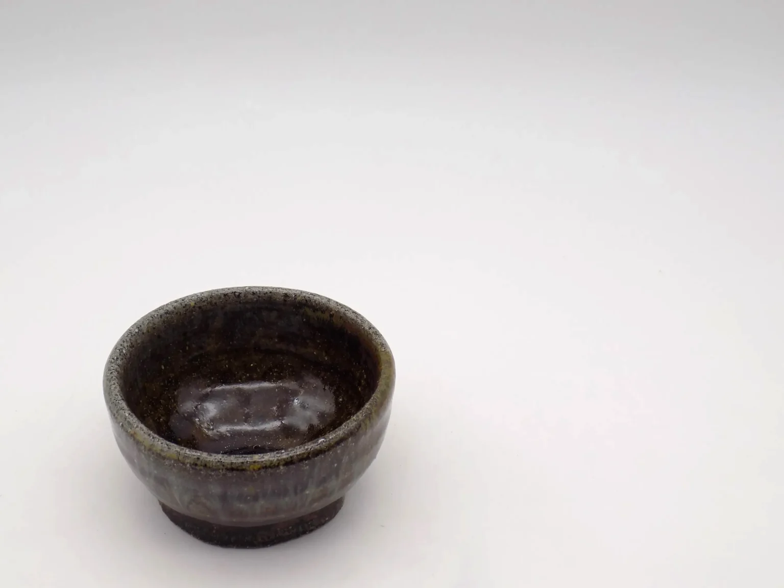 Wheel-thrown ochoko with ash and rice glaze, top view by Timi Lantos Ceramics