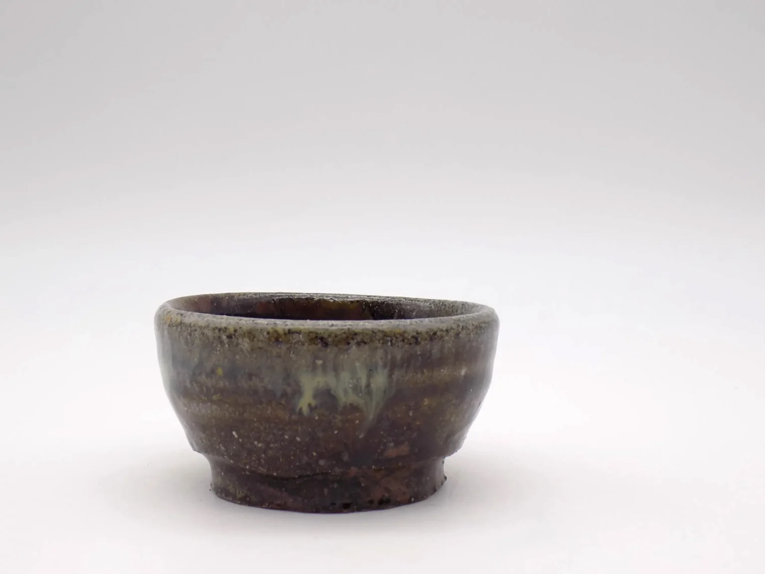 Wheel-thrown sake cup with brown ash glaze, side view by Timi Lantos Ceramics