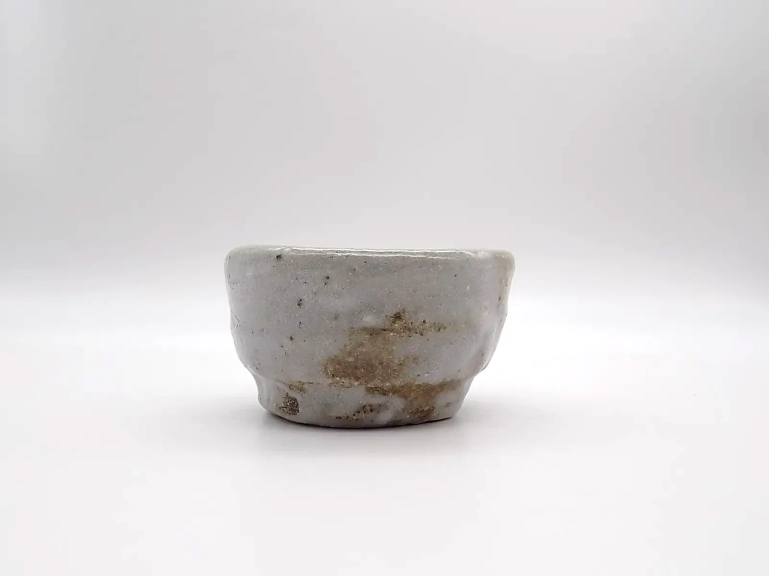Wheel thrown sake cup with Shino Mino glaze side view by Timi Lantos Ceramics