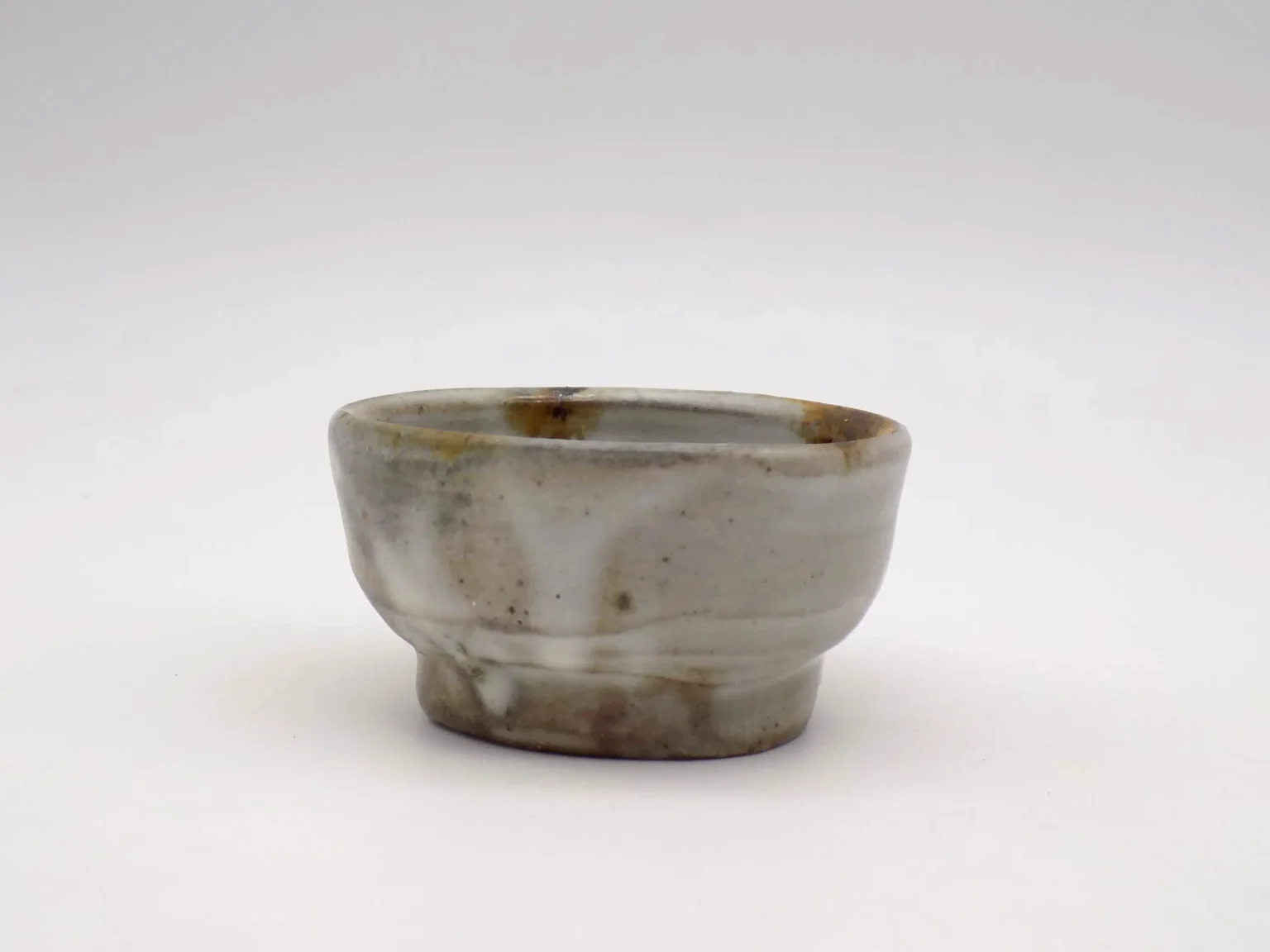 Wood-fired ochoko with ash glaze and slip, side view by Timi Lantos Ceramics