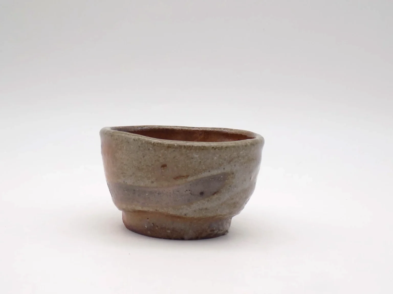 Wood-fired ochoko with red Shino and white glaze, side view by Timi Lantos Ceramics