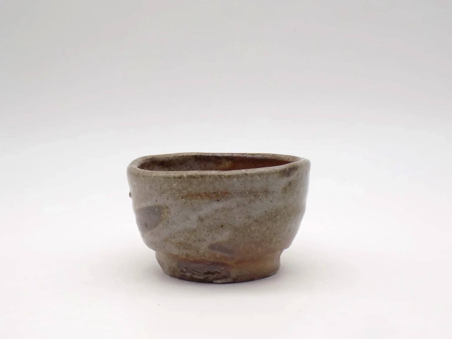 Wood-fired ochoko with rough gradiation in orange and white, side view by Timi Lantos Ceramics