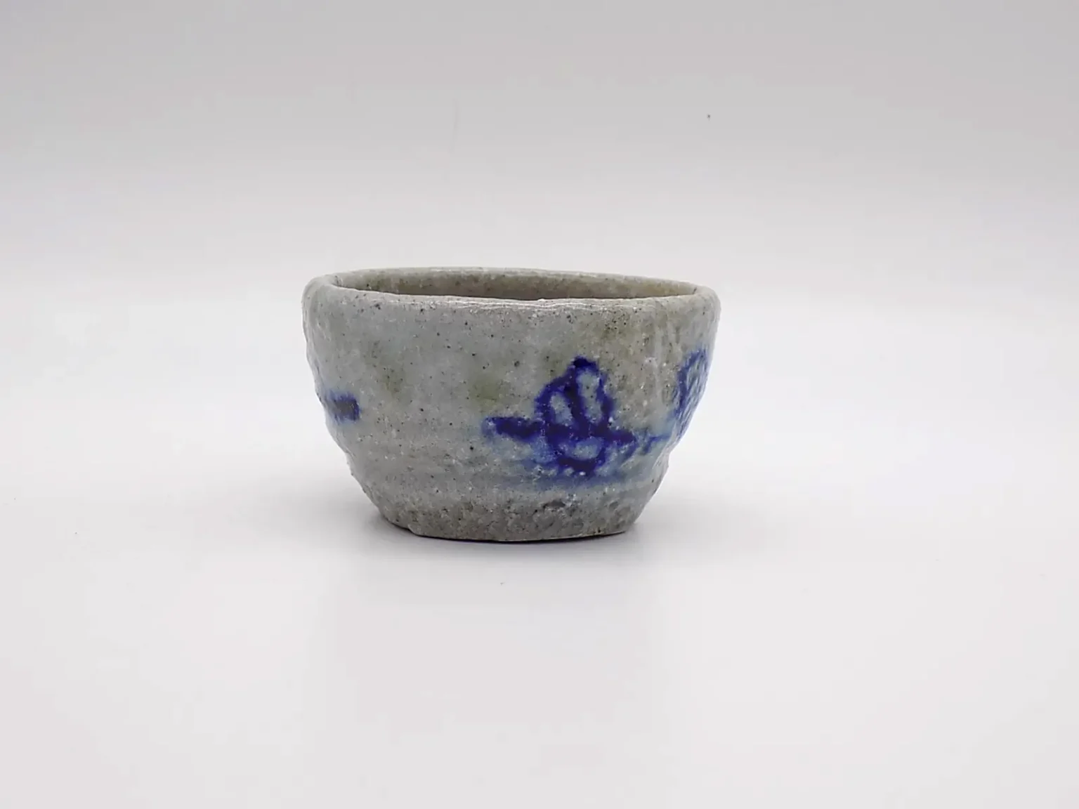 Wood-fired minimal white sake cup with blue hand-painted pattern, side view by Timi Lantos Ceramics