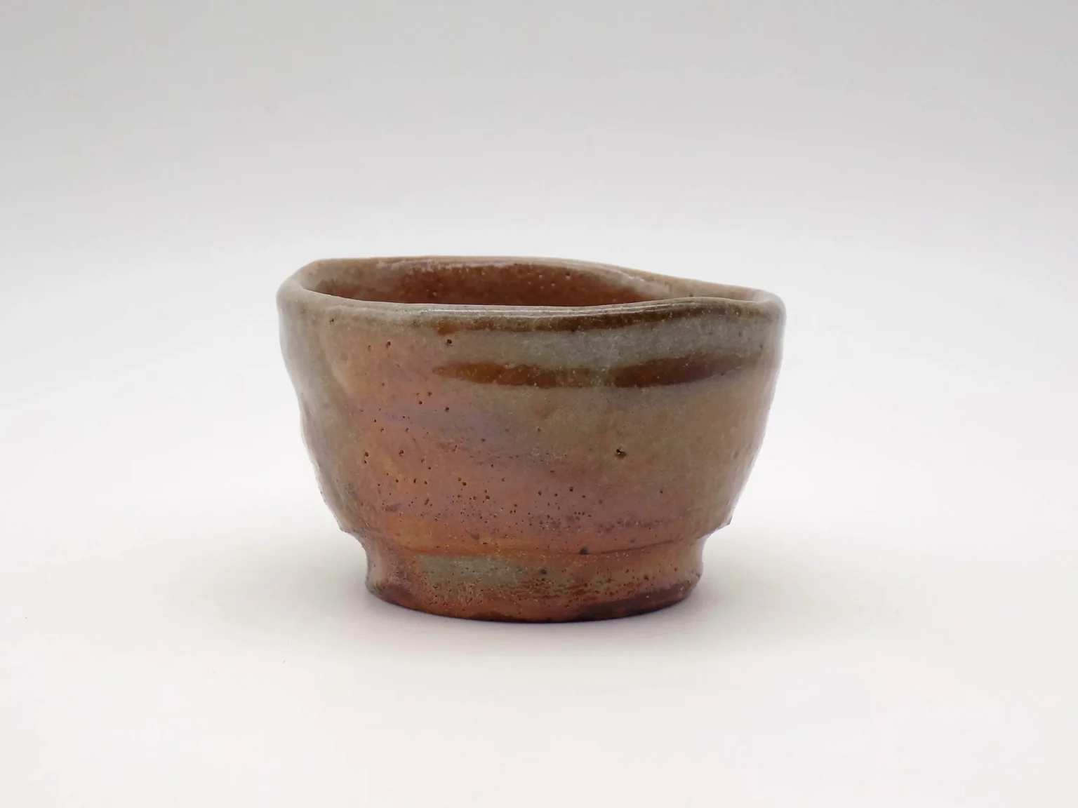Wood-fired sake cup with red Shino glaze, side view by Timi Lantos Ceramics