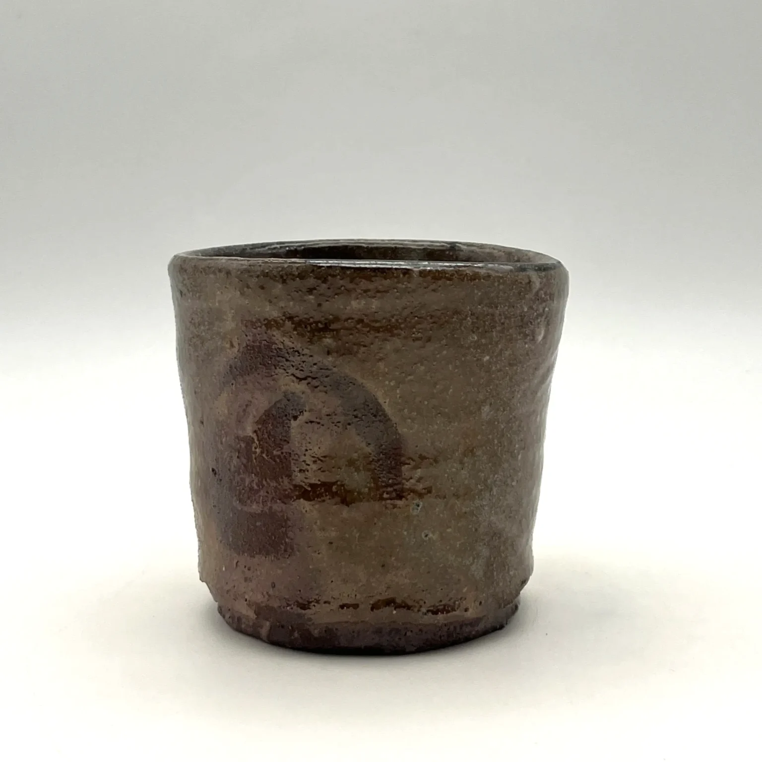 Asymmetrical shino glaze tea cup with orange and grey tones by Timi Lantos Ceramics