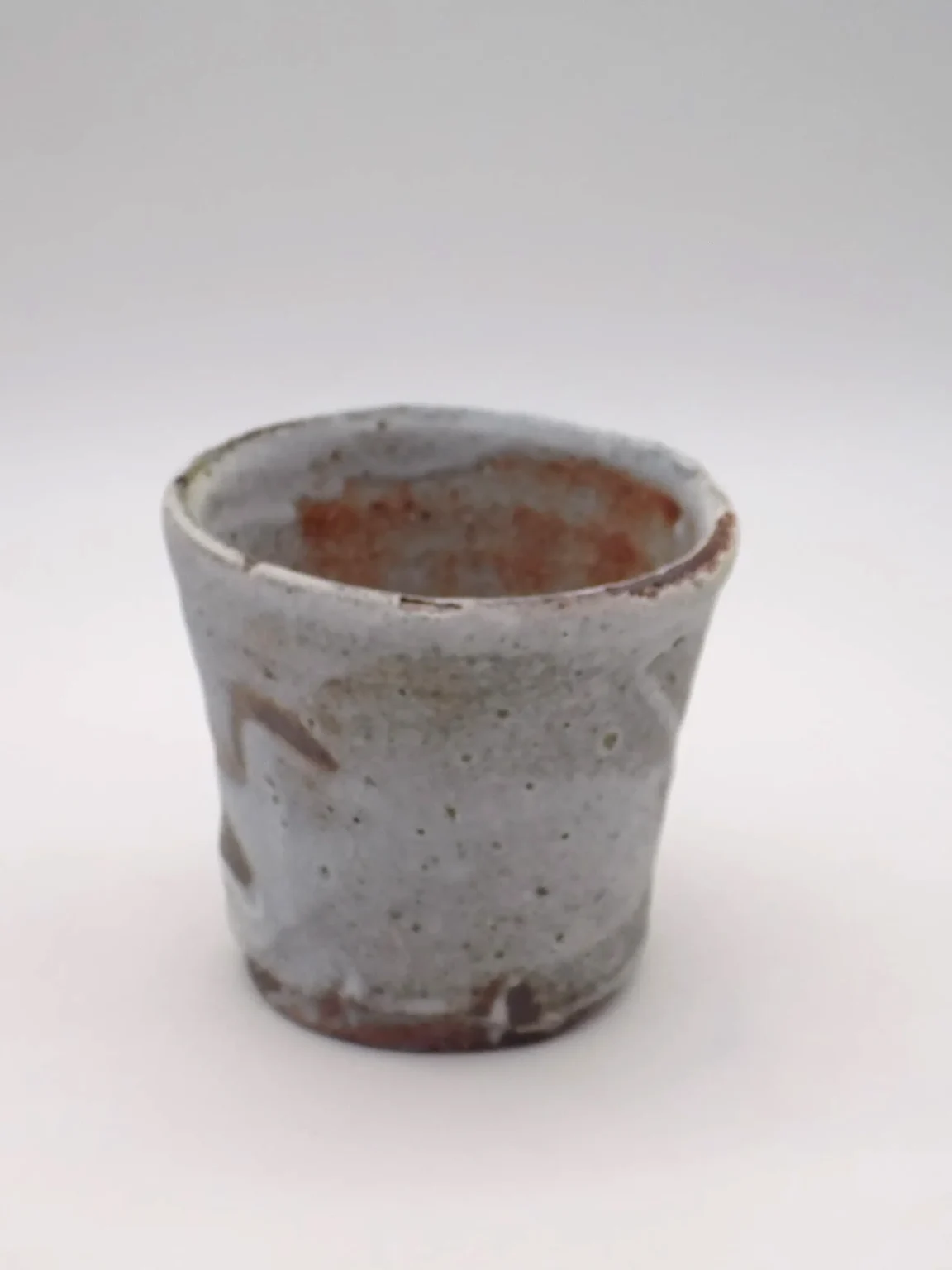 Shino glaze tea cup with speckled grey surface by Timi Lantos Ceramics