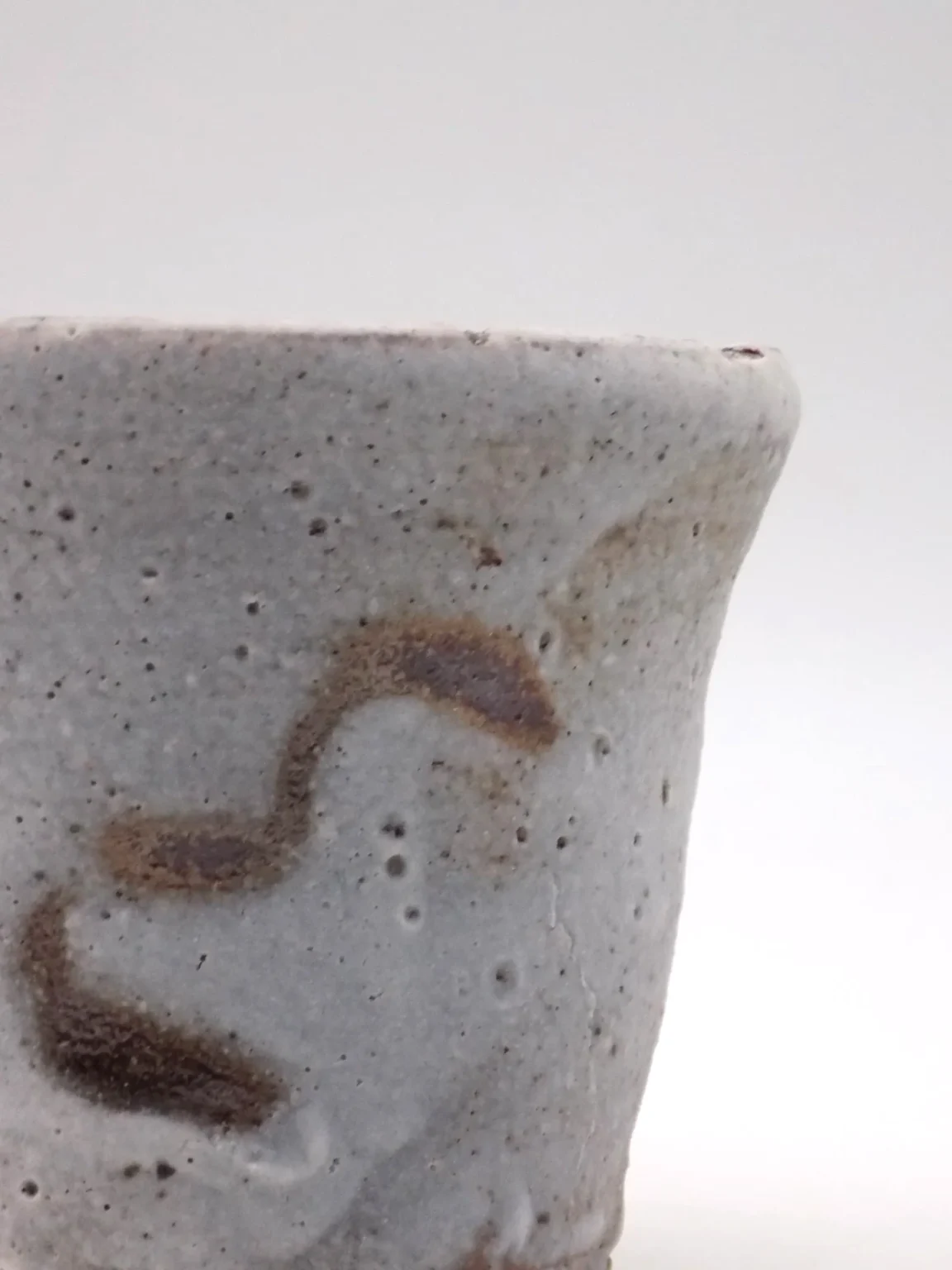 White wabi-sabi Japanese tea cup with rust colored fire marks by Timi Lantos Ceramics