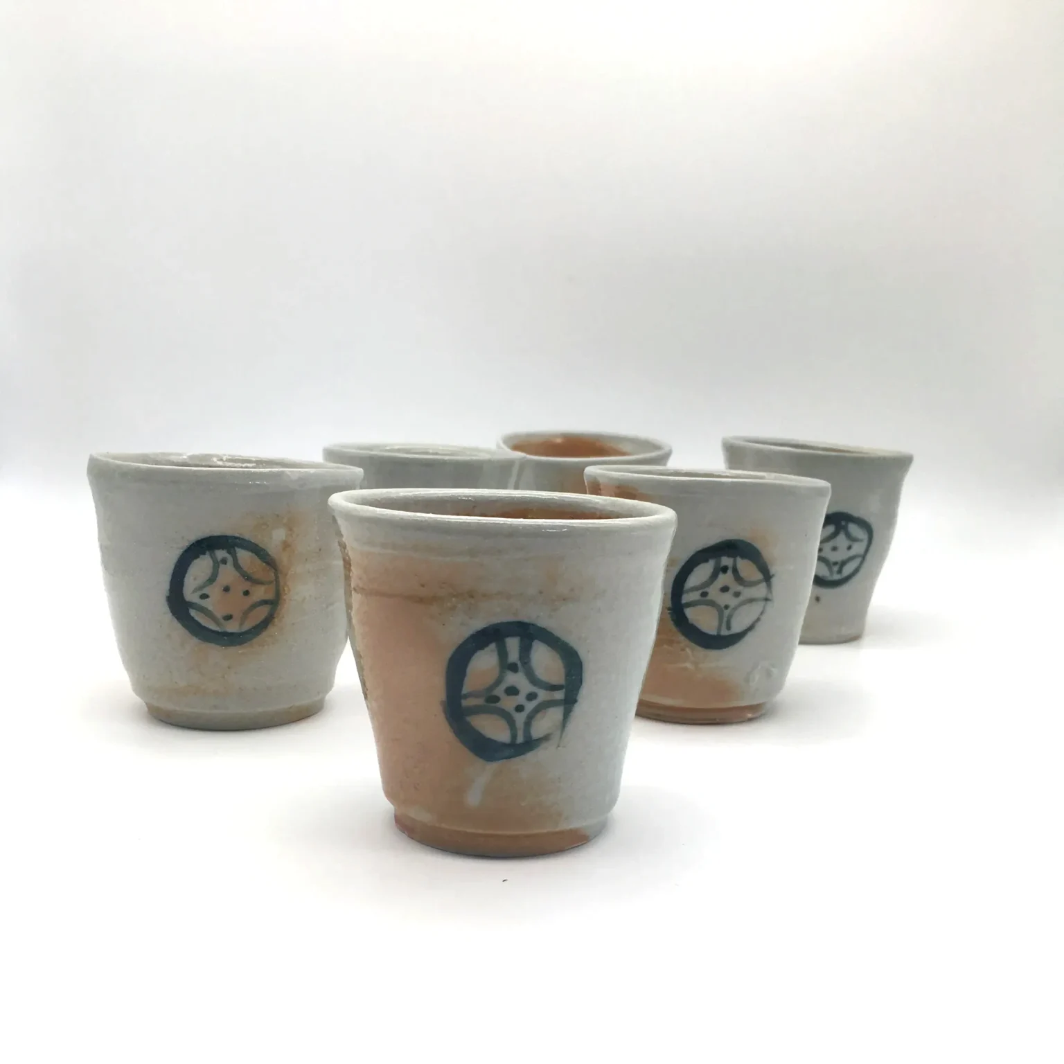 Wood fired porcelain tea cups with orange painted decoration by Timi Lantos Ceramics