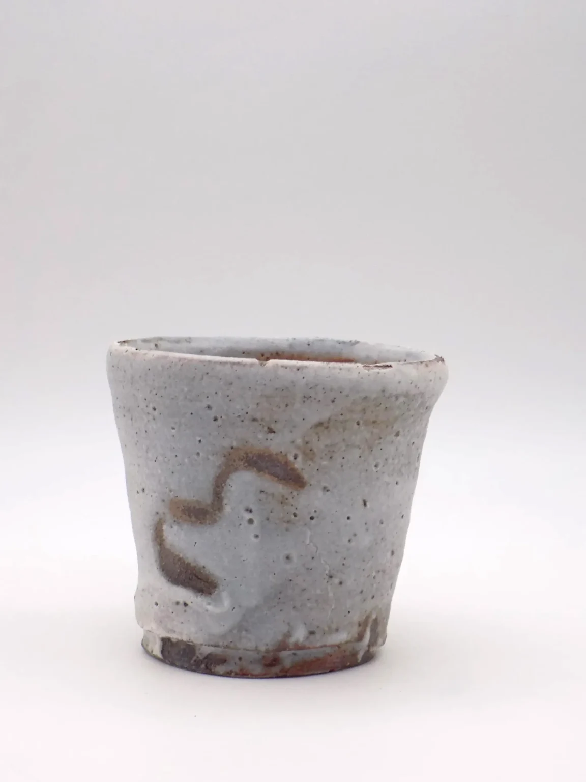 Hand thrown white wood fired yunomi tea cup with rusty tones by Timi Lantos Ceramics